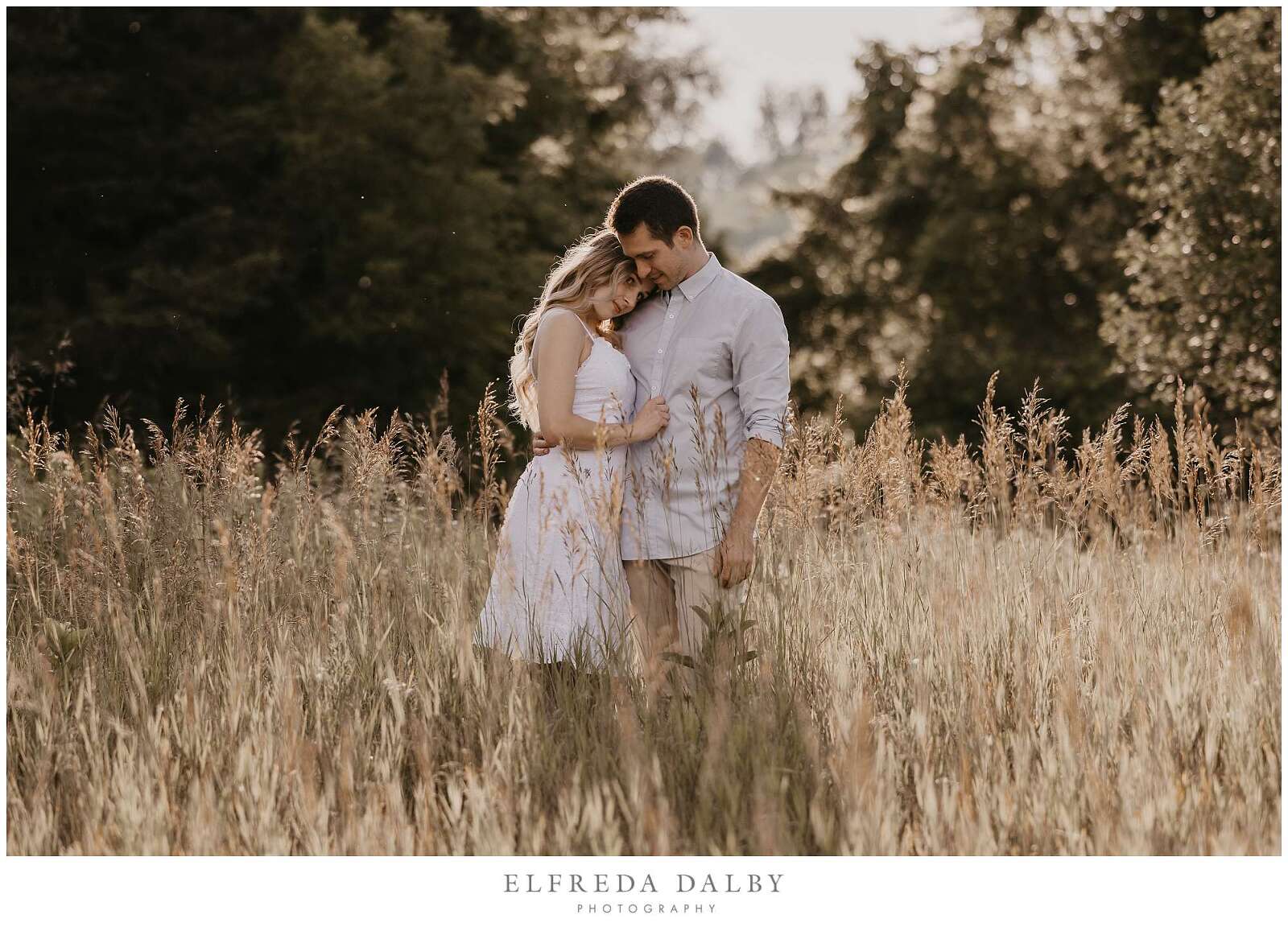 Couple standing in a field with beautiful golden light