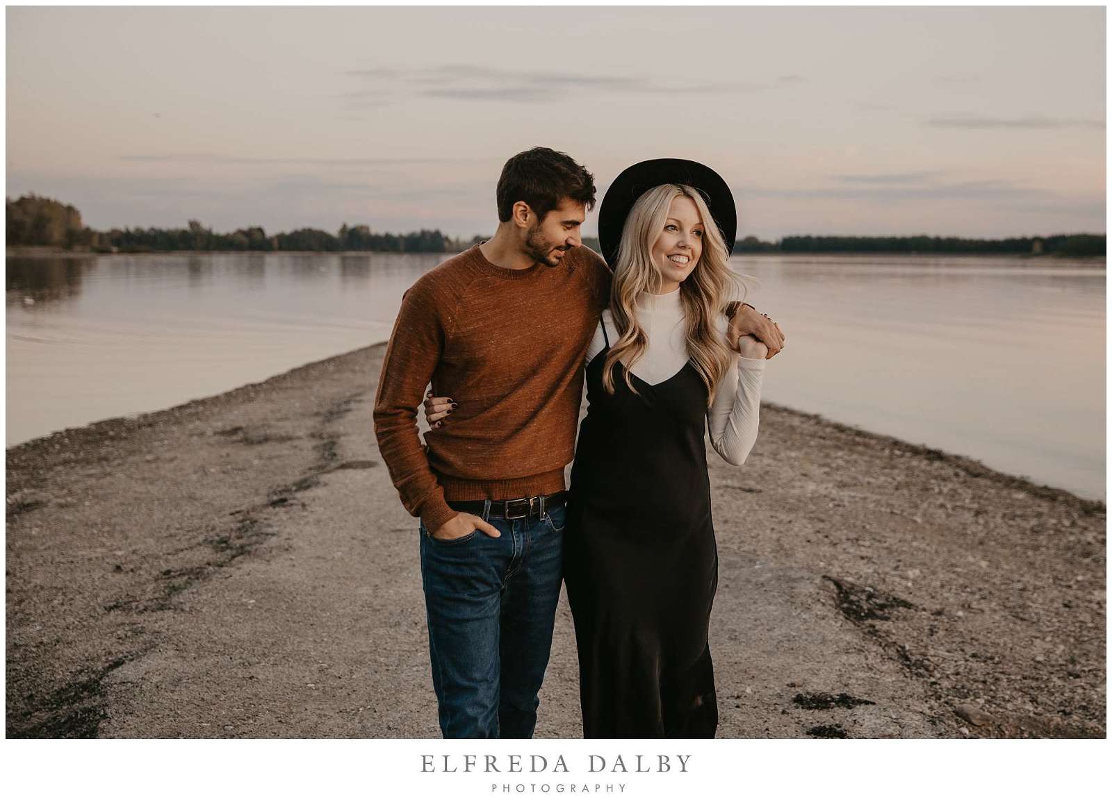 Beautiful engaged couple walking on the pier at Guelph Lake