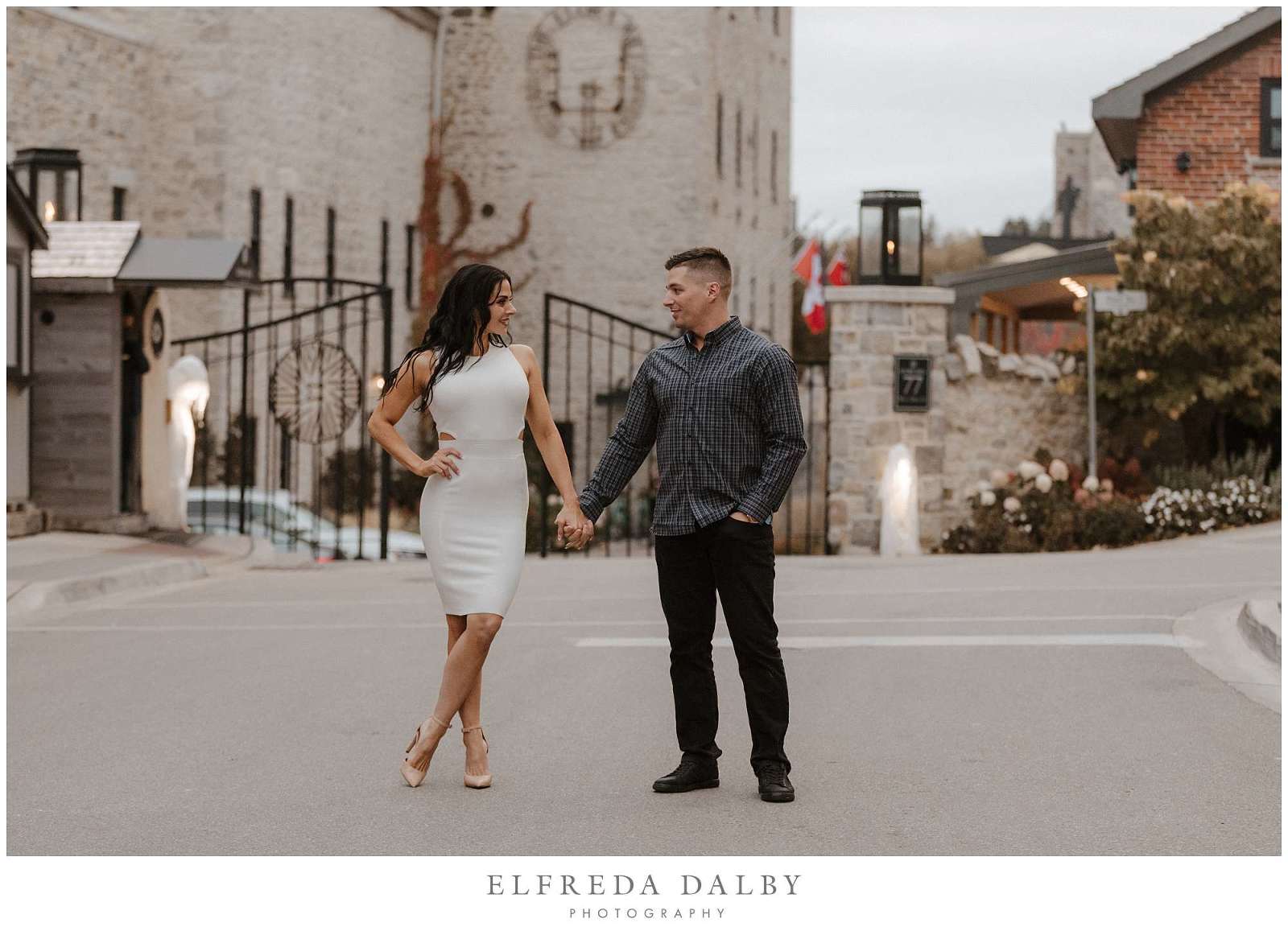 Beautiful engaged couple standing in front the Elora Mill