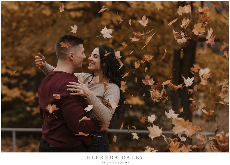 Leaves falling over engaged couple during their engagement session