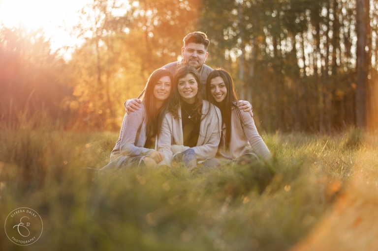 Beautiful family photo of brother and sisters at golden hour 