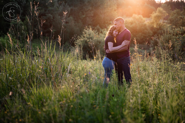 Couple standing in field during golden hour Kitchener