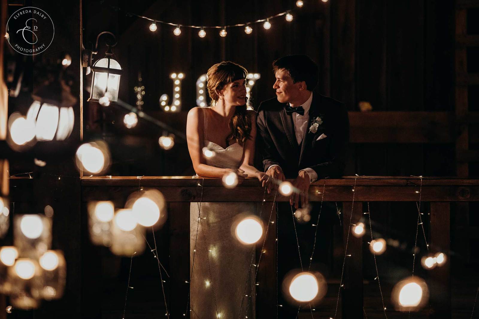 Bride and groom between lots of little lights