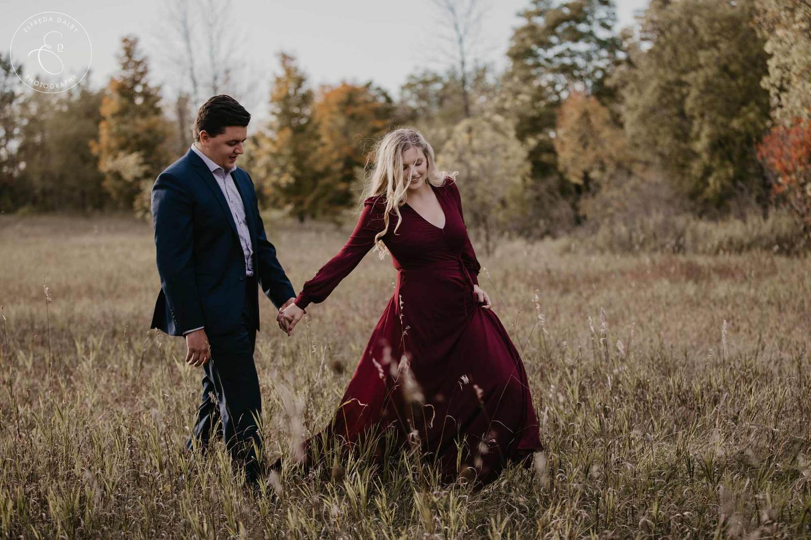 Engaged couple walking in a field