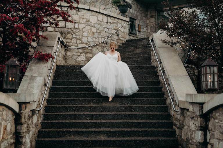 Bride walking down the stairs in front of Cambridge Mill