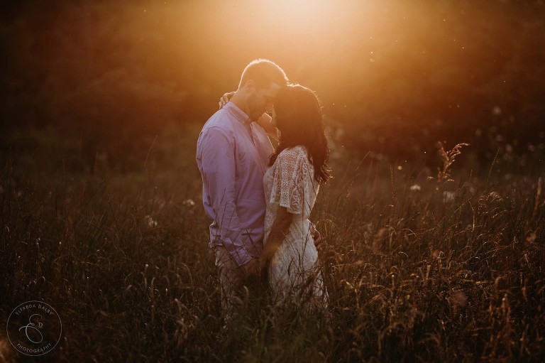 Couple standing in a field during golden hour