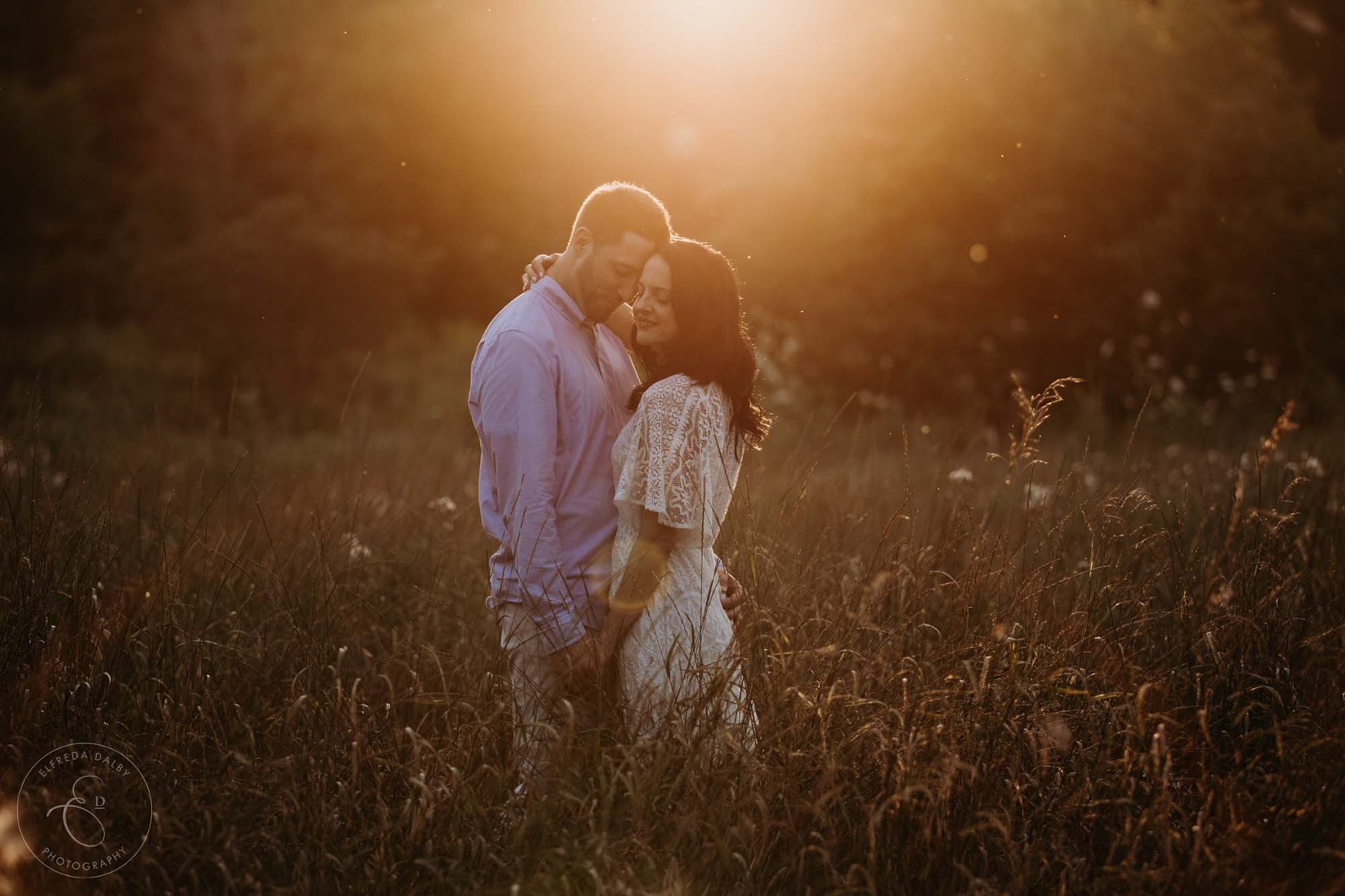 Beautiful couple standing in a field during golden hour