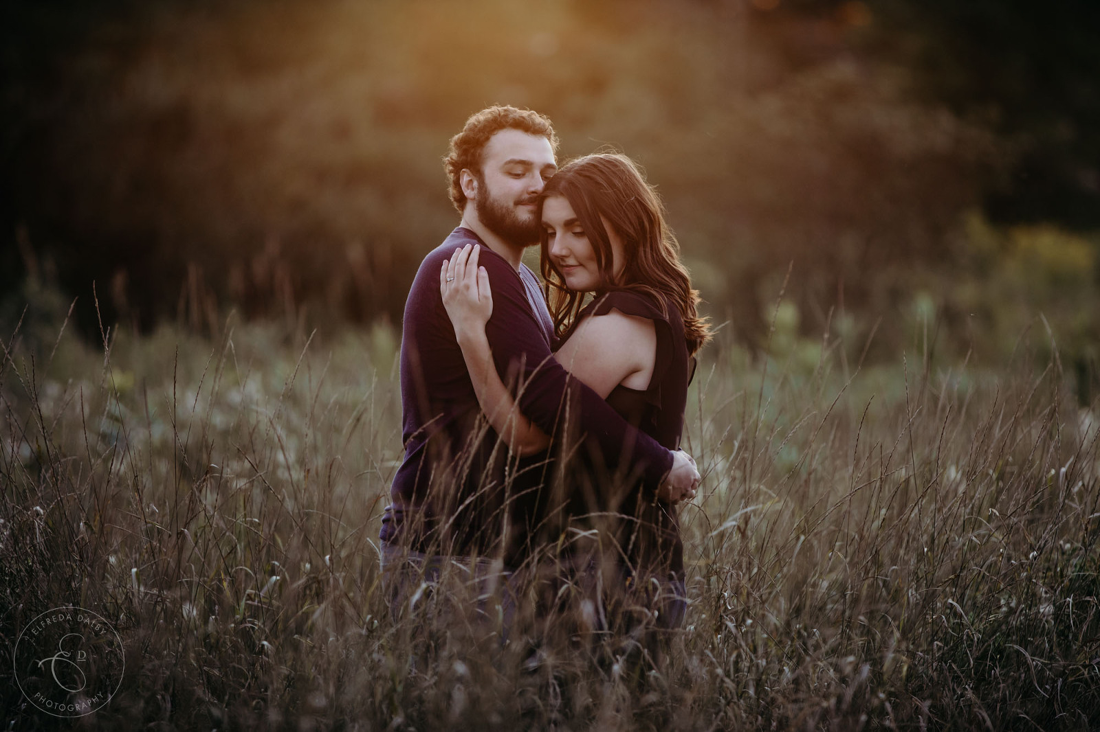 Couple standing in a field during golden hour