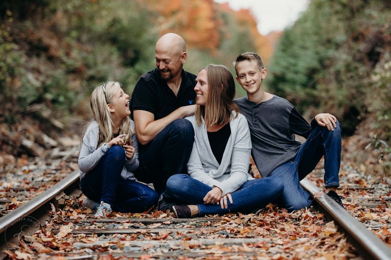 Fun family sit on a train track