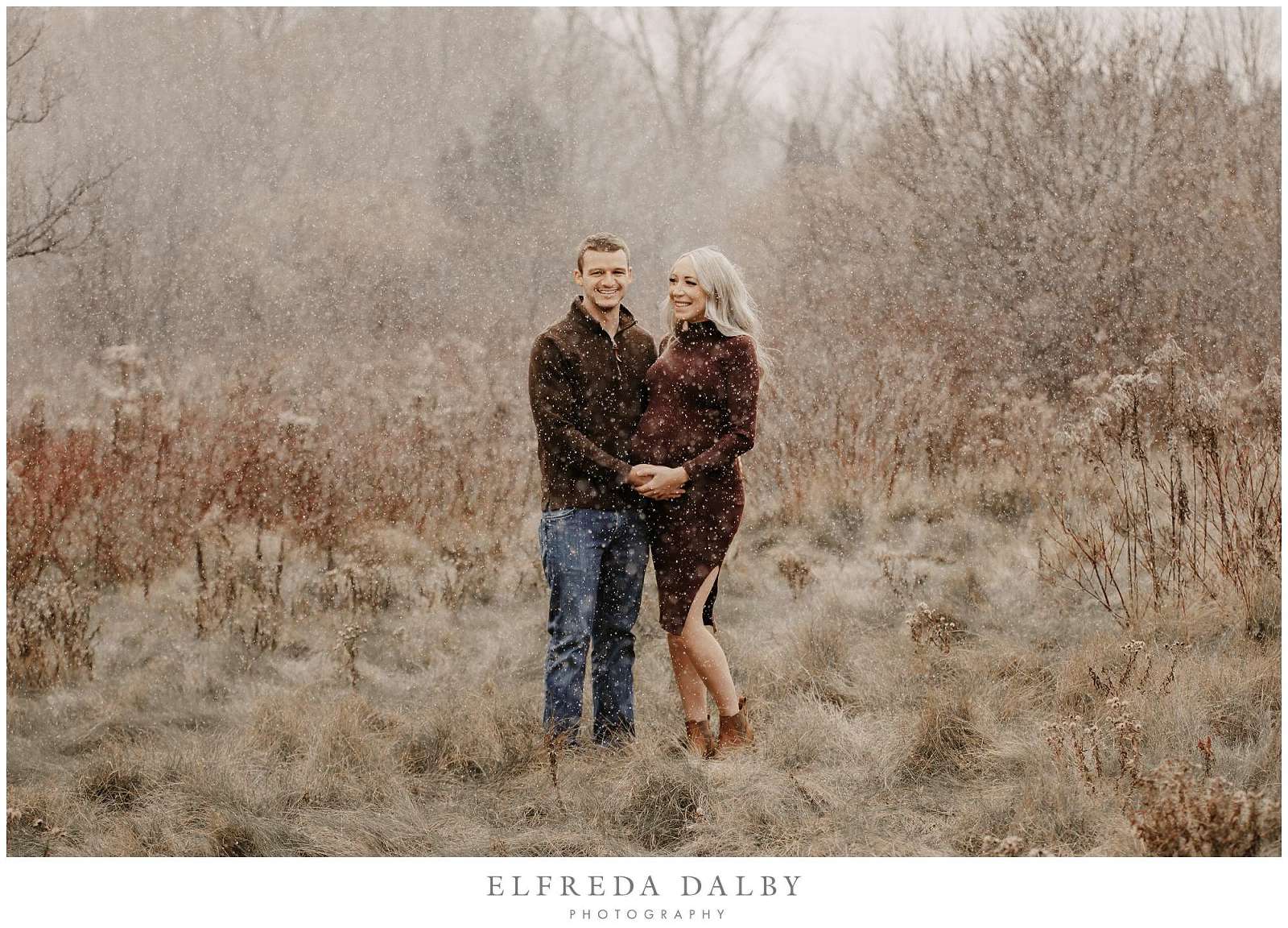 Beautiful couple standing in the snow during their maternity session