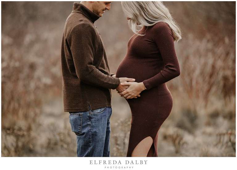 Beautiful expected mom and her husband holding her tummy