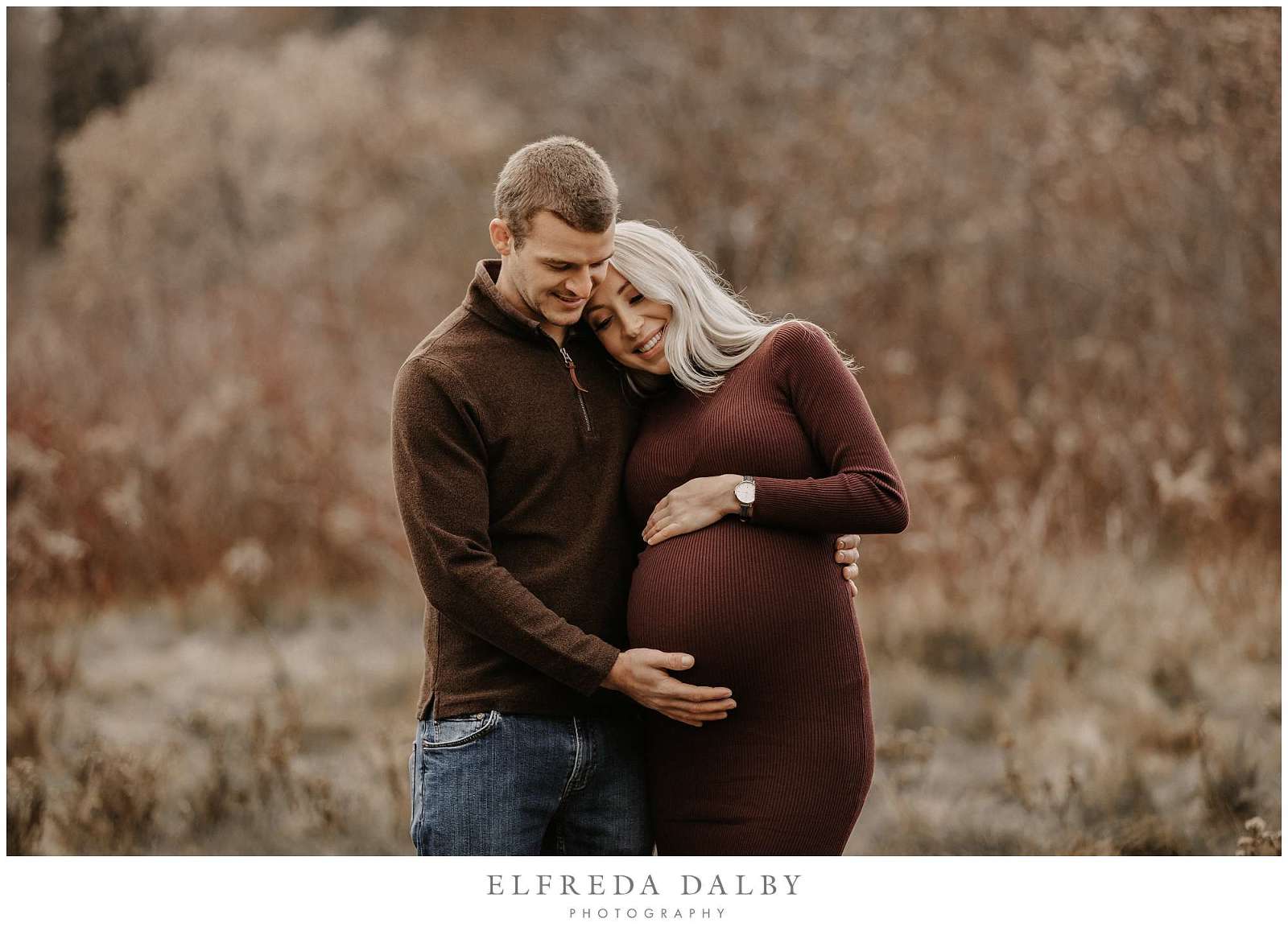 Beautiful couple standing in a field during their maternity session