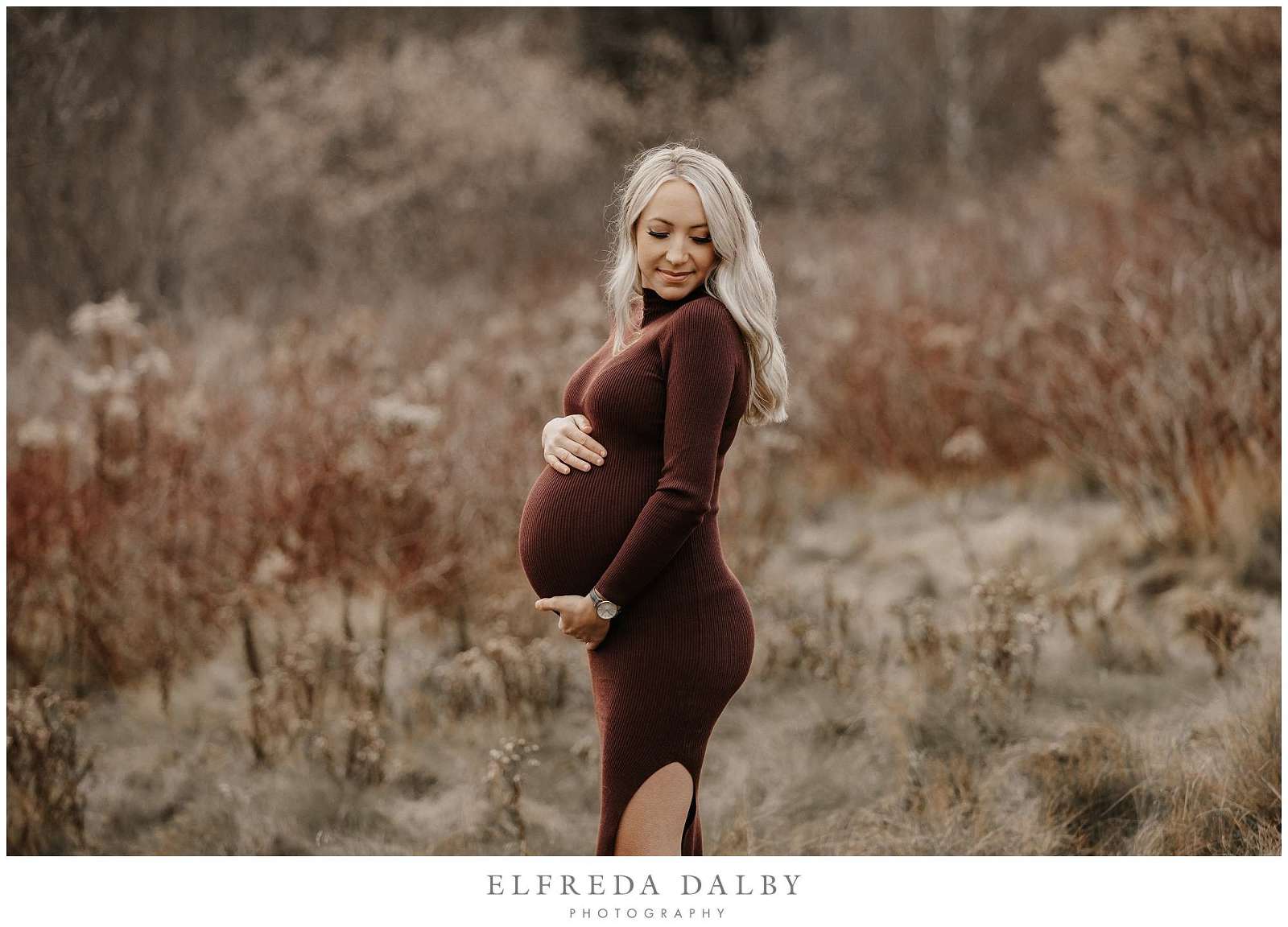 Gorgeous blonde pregnant mom holding her tummy