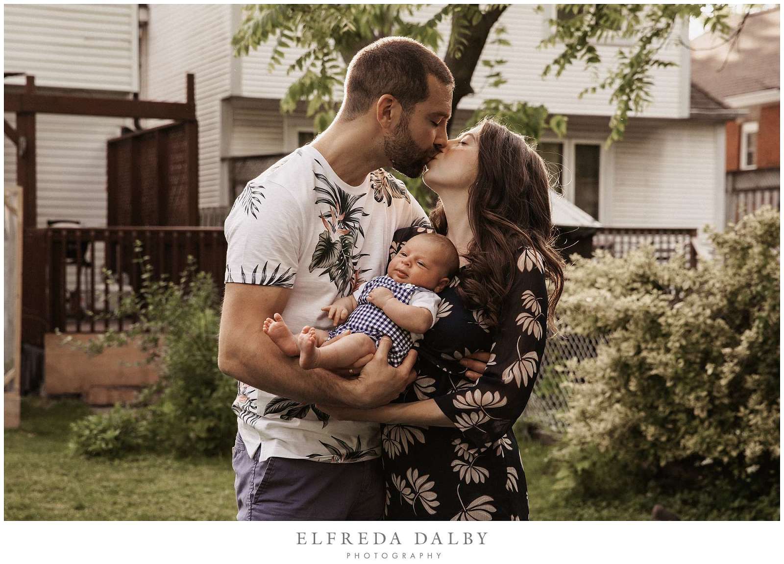 Mom and kissing while holding their baby boy