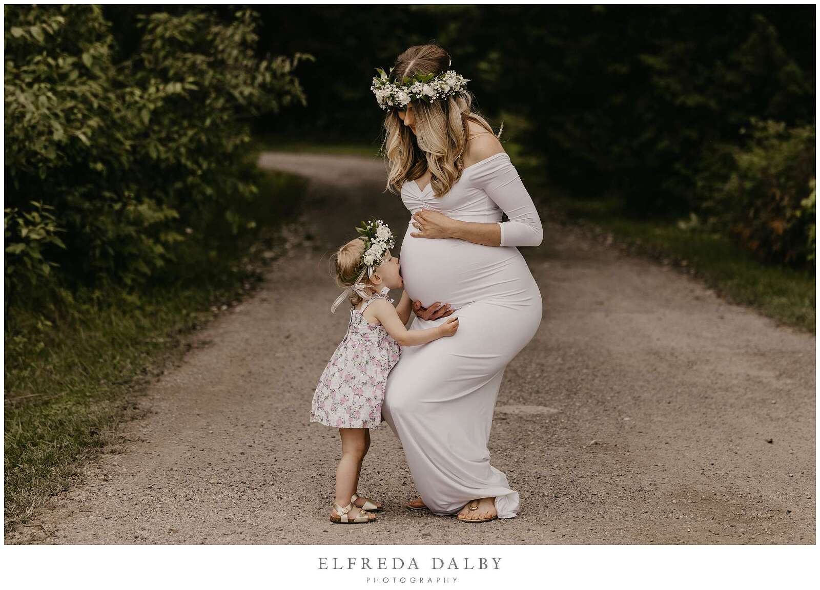 Little girl kissing her pregnant mommy's tummy