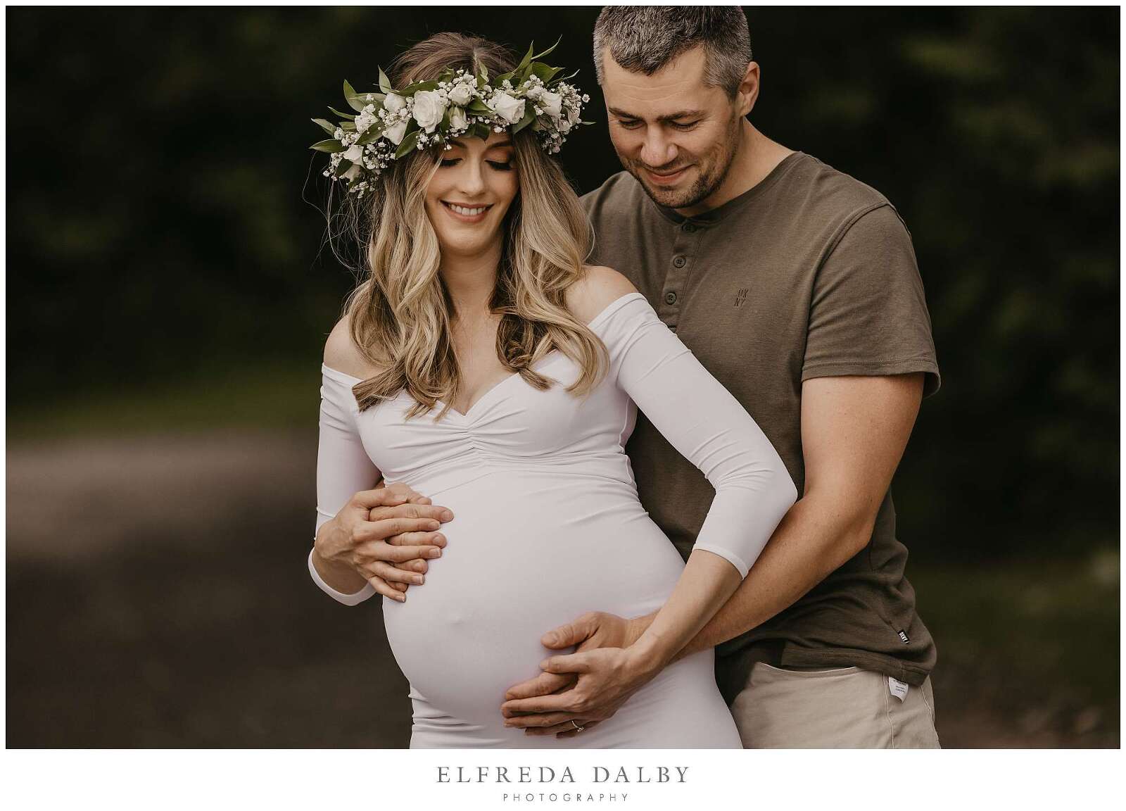 Pregnant woman with her husband looking down at her tummy