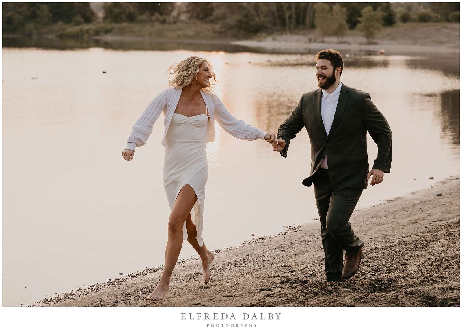 Engaged couple running on the beach during sunset