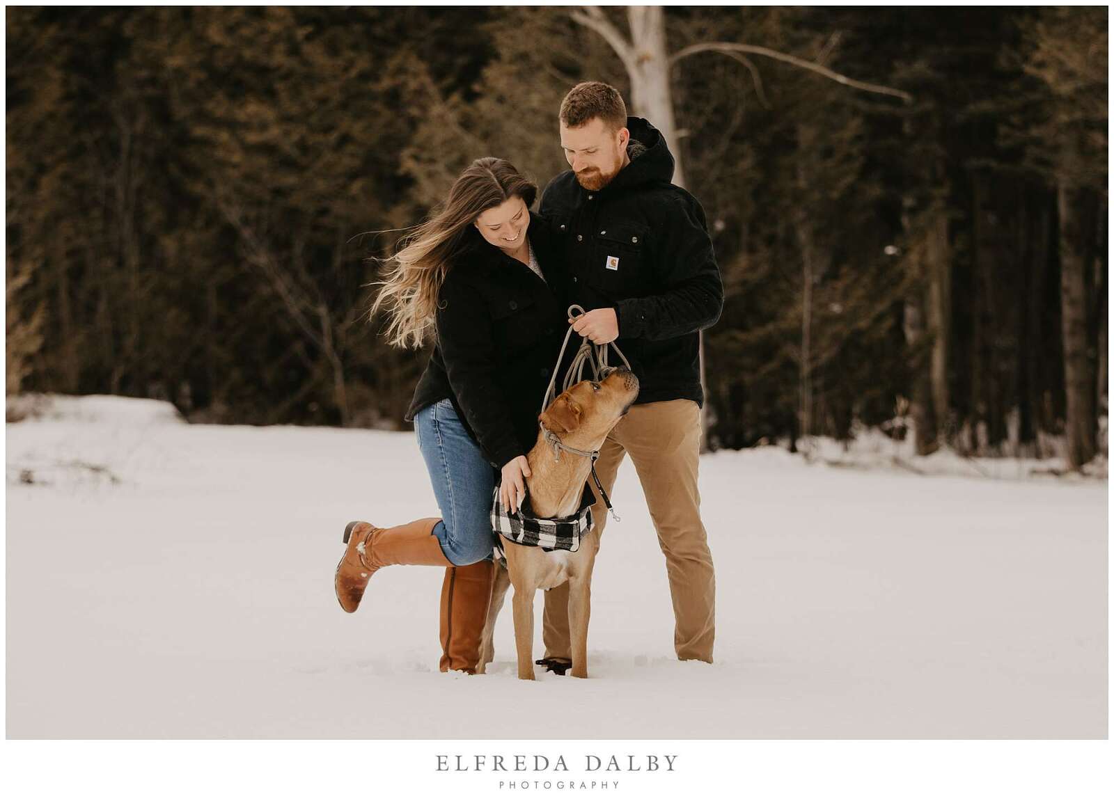 Winter engagement session with their dog in the snow