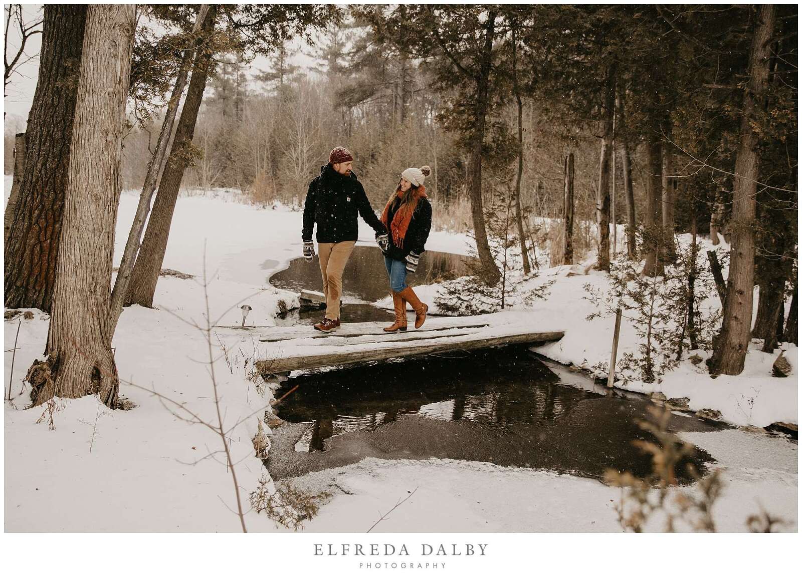 Couple walking over a bridge in the snow