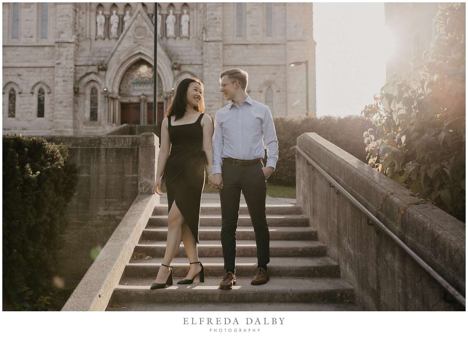 Couple standing on the stairs in front of a church