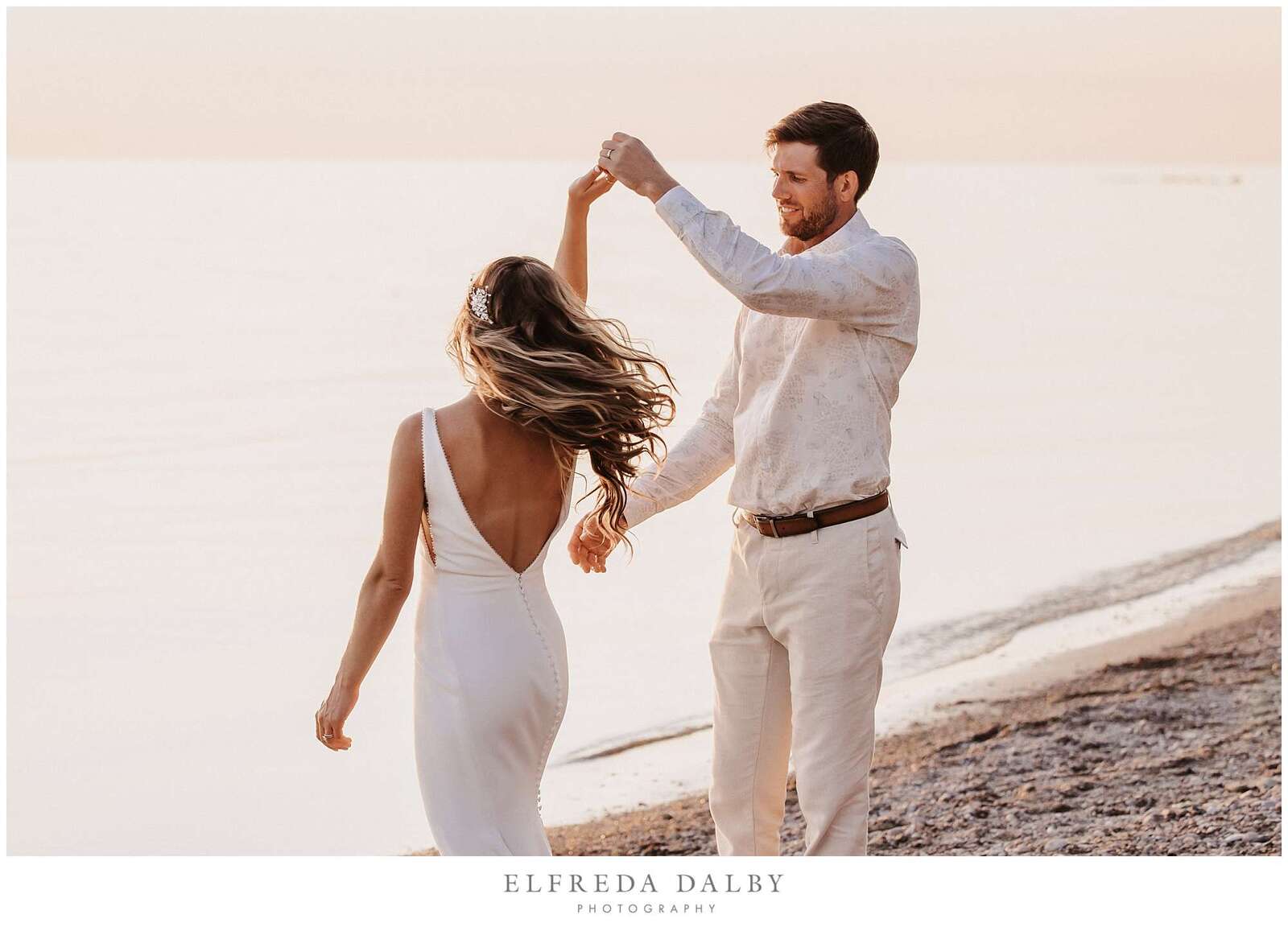 Groom spins his bride on Kincardine beach at sunset