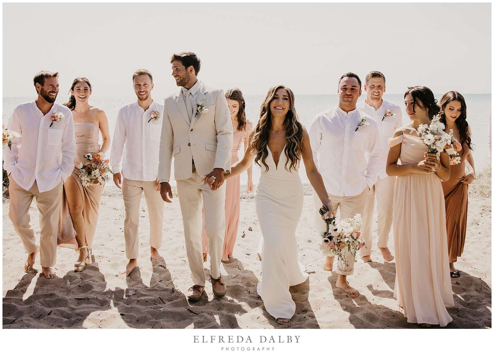 Bridal party walking on the beach
