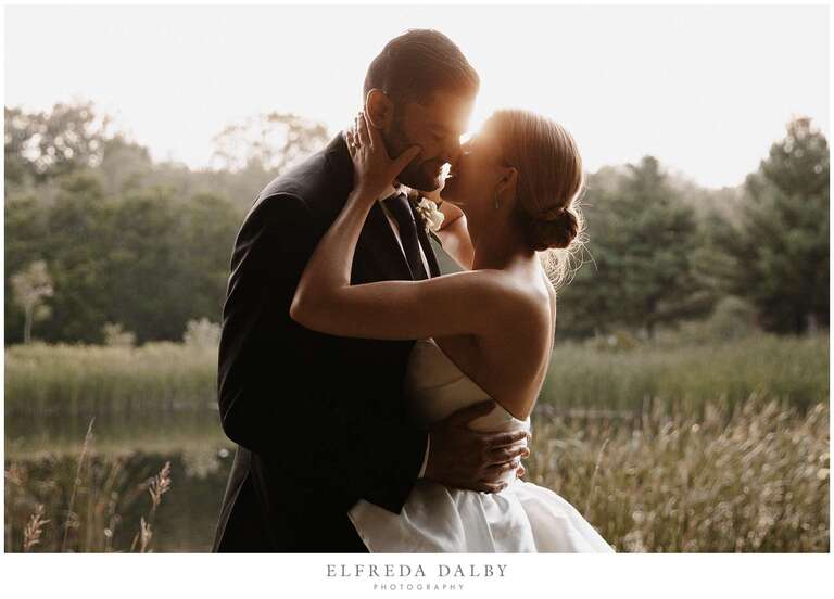 Bride and groom kissing at sunset