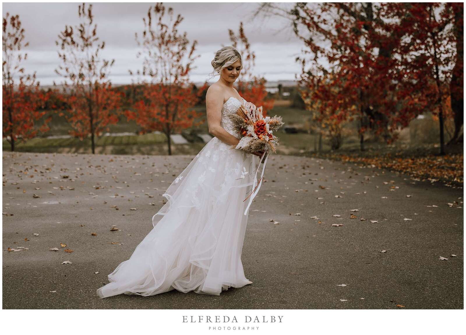 Gorgeous bride looking at her flowers at Earth to Table Farm