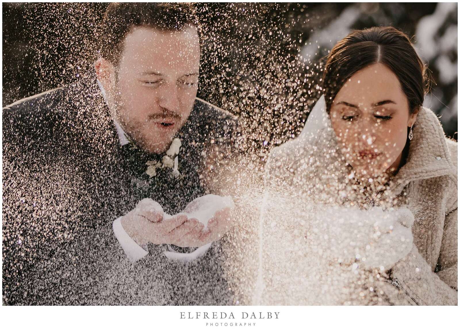 Bride and groom blow snow out of their hands in Elora