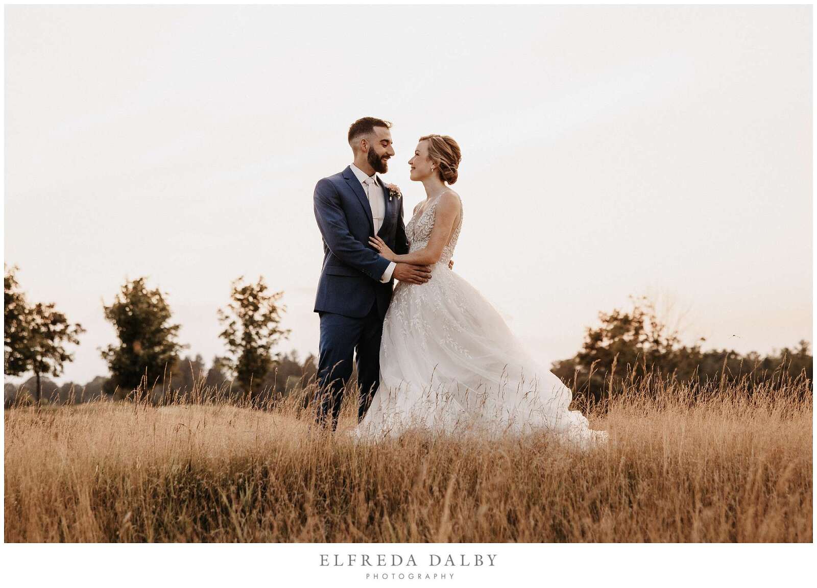 Bride and groom walking through a grassy field at Whistle Bear Golf Club