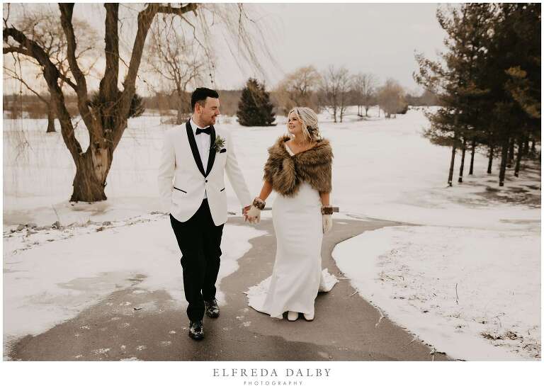 Bride and groom walking in the snowy path at MontHill Golf & Country Club