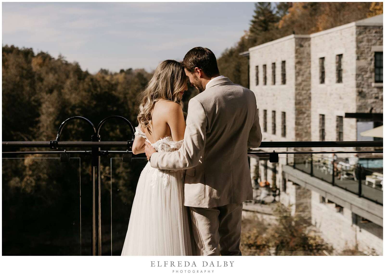 Bride and groom on the balcony looking over the river at the Elora Mill