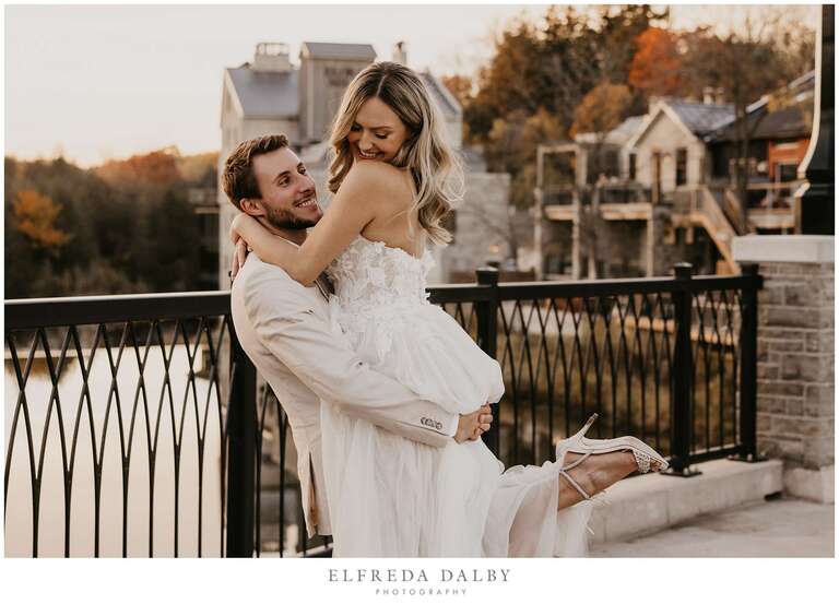 Groom picking up his bride on the bridge in Elora 