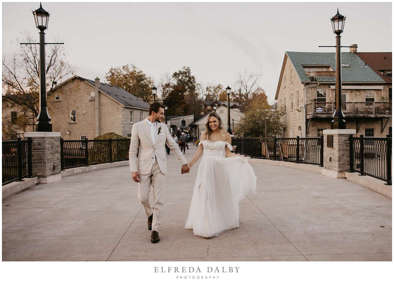 Bride and groom walking on the bridge in Elora