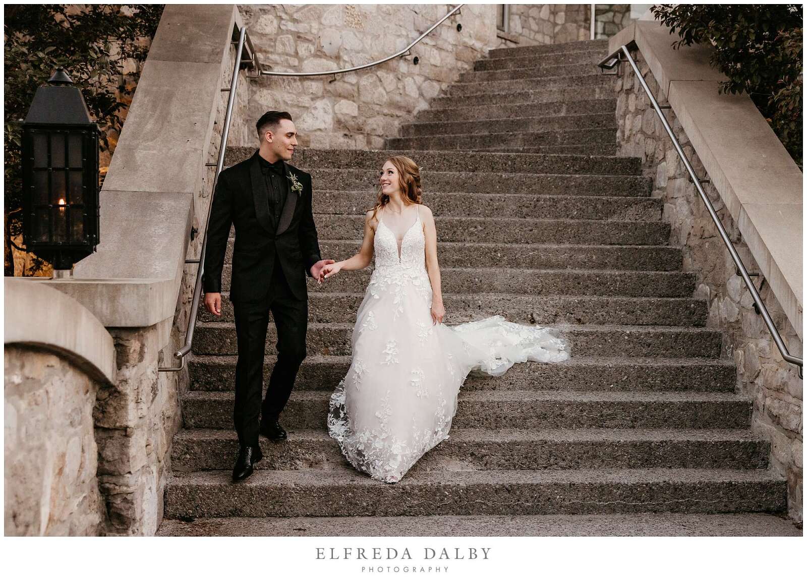 Bridge and groom walking down the stairs in front of the Cambridge Mill