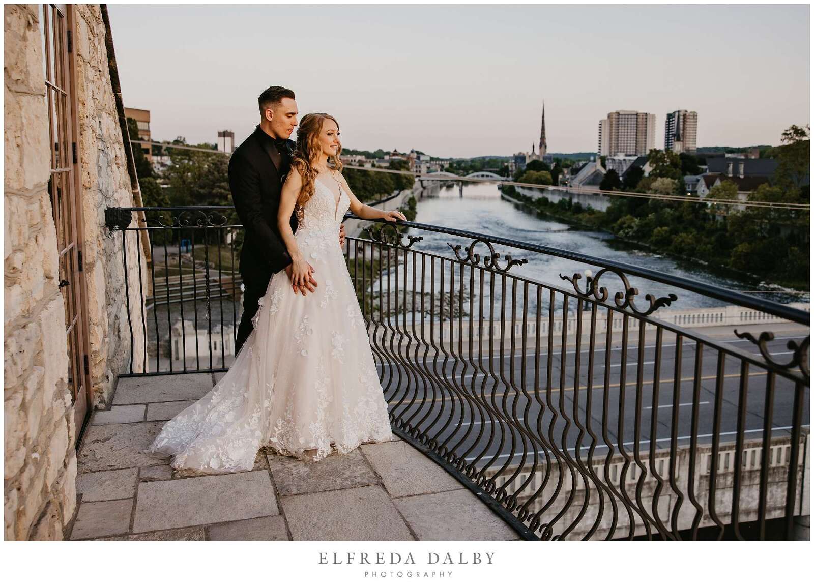 Bridge and groom standing on the Juliette balcony during sunset at Cambridge Mill