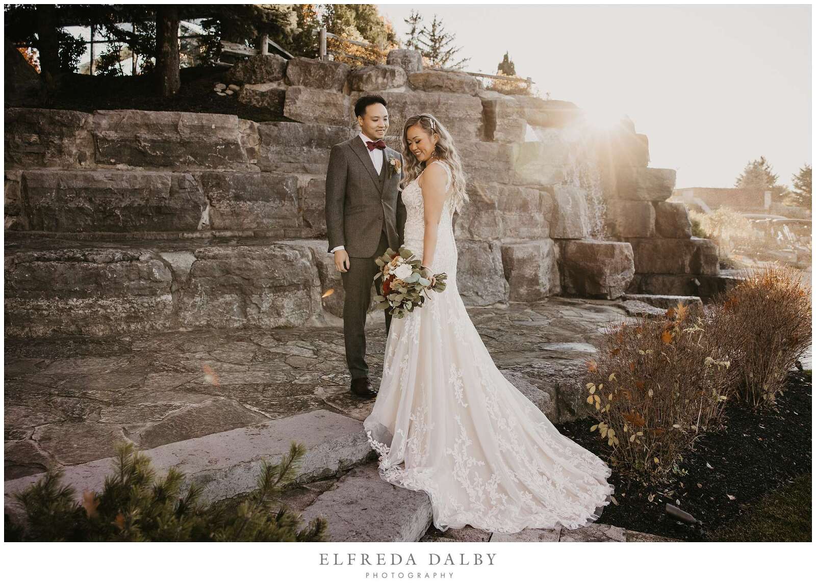 Bride and groom standing in front of the waterfall at Whistle Bear Golf Club